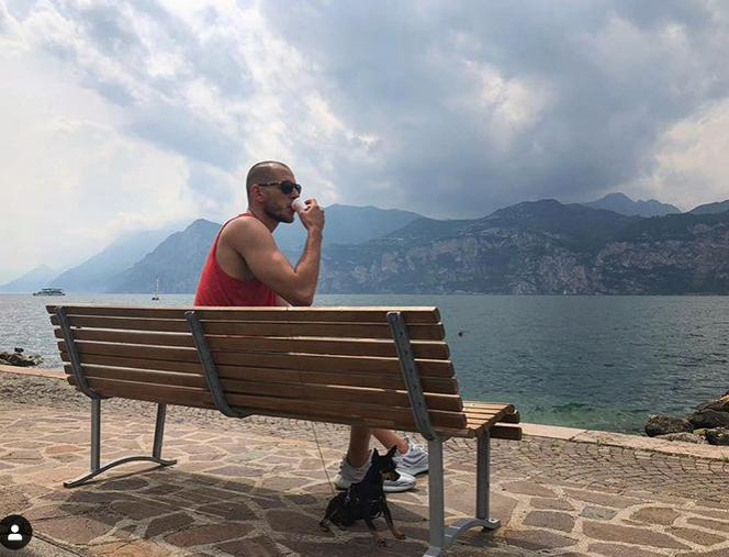 Bartosz Kurek popija winko