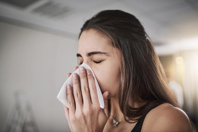 kobieta wydmuchująca nos z powodu alergii