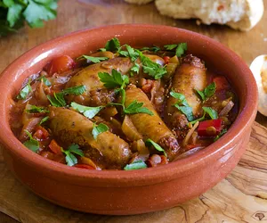 Zapiekane kiełbaski z grzankami czosnkowymi. Sycący obiad dla całej rodziny