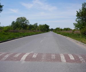 Absurd drogowy pod Warszawą. Droga przez łąki, a na niej osiem progów zwalniających