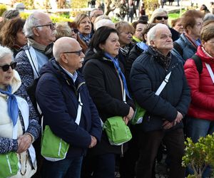 Wierni modlą się o zdrowie Franciszka przed pomnikiem Jana Pawła II. Składają kartki z życzeniami i wiązanki z białych róż