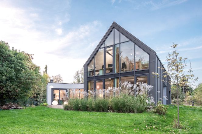 Nowoczesny dom stodoła wśród tradycyjnej zabudowy