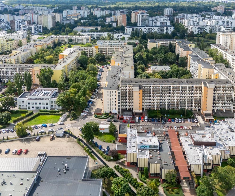 Osiedle Przyczółek Grochowski w Warszawie z perspektywy lotu ptaka. Meandrujący blok o różnej wysokości, otoczony zielenią i parkingami. W tle widoczne inne budynki mieszkalne stolicy. Więcej o architekturze tego osiedla przeczytasz na Architektura Murator Plus.