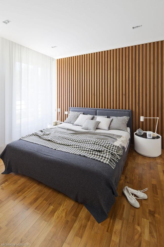Drewniana ściana za łóżkiem w sypialni