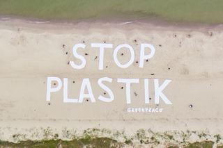 Wielki napis Stop plastik na plaży w Kołobrzegu
