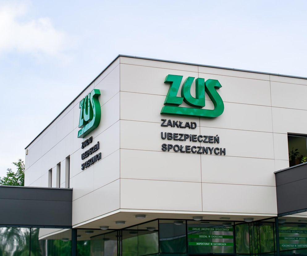 Nowoczesny budynek Zakładu Ubezpieczeń Społecznych z dużym zielonym logo ZUS i napisem Zakład Ubezpieczeń Społecznych na beżowej fasadzie, symbolizujący zmiany i automatyzację w systemie emerytalno-rentowym, o czym możesz przeczytać na Super Biznes.
