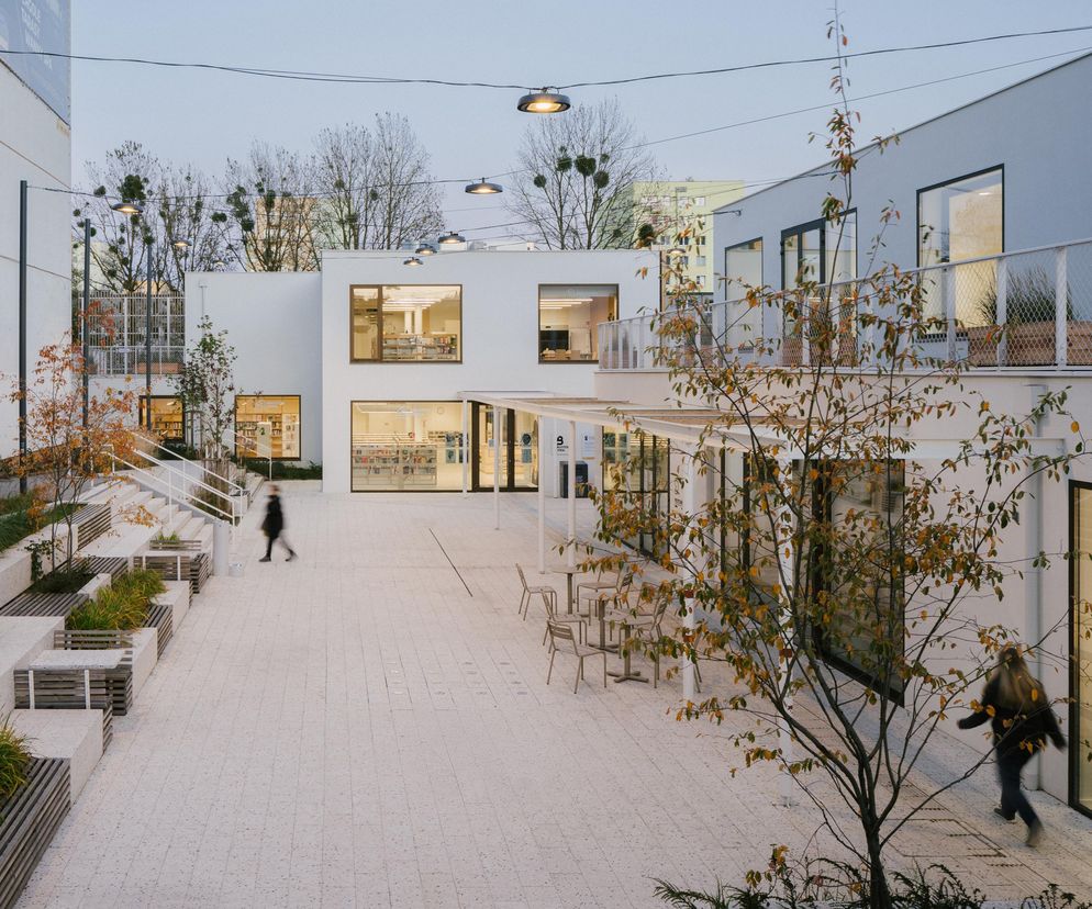 Nowoczesne Centrum Sąsiedzkie z Biblioteką Miejską w Gdyni, Widna 2a, autorstwa IPA, PB Studio, Studiomania. Białe elewacje, drewniane akcenty, amfiteatralne siedziska i jasne terrazzo tworzą otwartą przestrzeń integrującą mieszkańców. Na Architektura Murator Plus przeczytasz więcej o tej inspirującej realizacji.