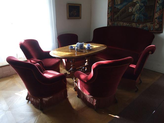 Salonik w stylu Ludwika Filipa. Fotele i kanapa w typie crapaud stoją wokół stolika o charakterystycznej, rozrzeźbionej nodze.