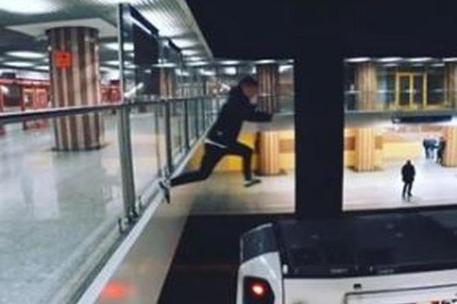 Młody mężczyzna skacze na dach pociągu metra