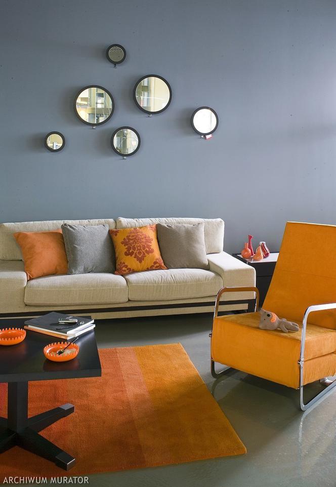 Szara kanapa z pomarańczowymi poduszkami