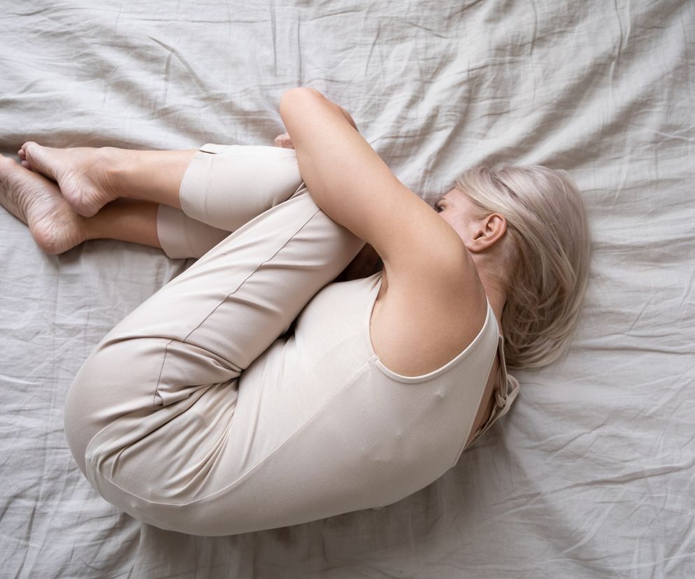 Kobieta w średnim wieku leży smutna na łóżku