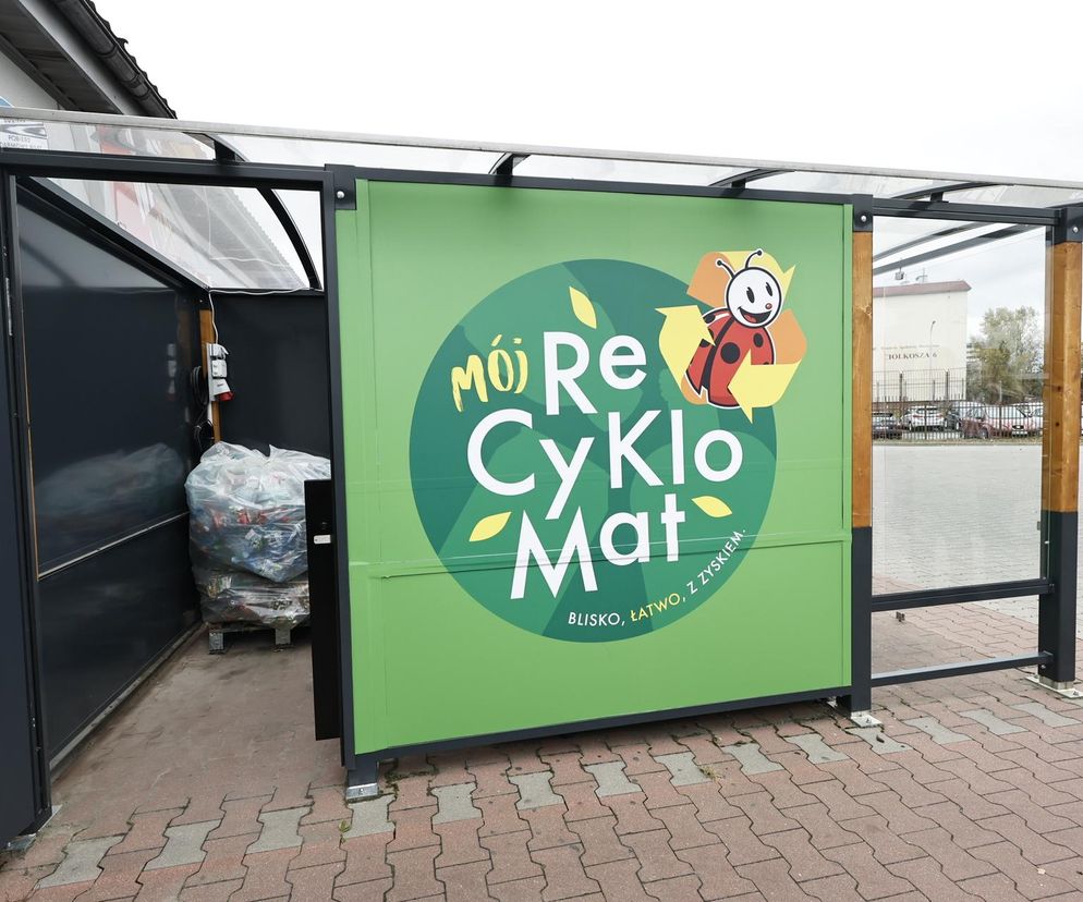 Zielony recyklomat Biedronki z logotypem „Mój Recyklomat” i biedronką w tle symbolizuje nowe zasady zwrotu kaucji za opakowania. Klienci mogą zwrócić butelki i puszki, otrzymując środki do e-portfela w aplikacji. Więcej na Super Biznes.