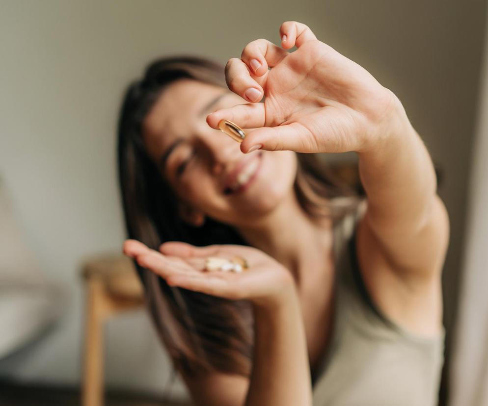 Kobieta pokazująca tabletki z witaminami