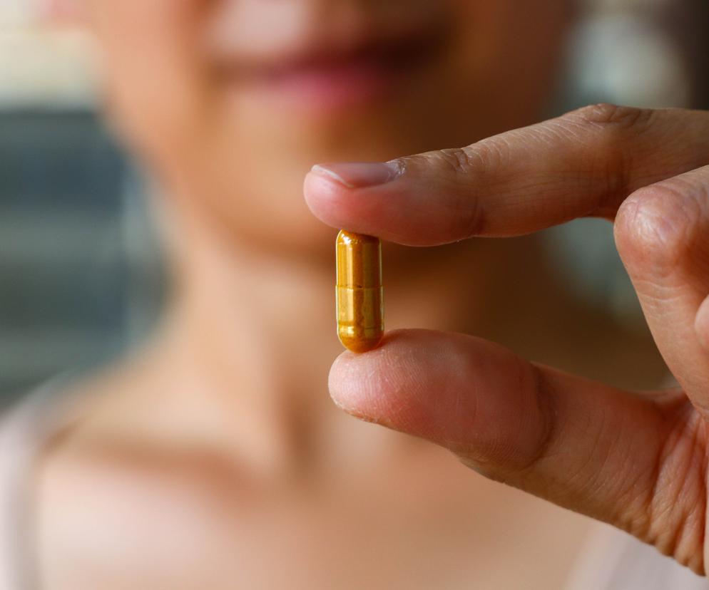 Kobieta trzymająca pigułkę w ręce 