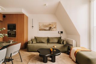 62-m mieszkanie w stylu mid-century. W środku beżowa kuchnia z drewnem