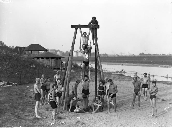 Plażowicze podczas wypoczynku i zabawy na huśtawce. Zdjęcie zrobione w 1929 roku 