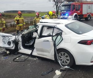 Tragiczny wypadek pod Lesznem. Przód osobówki został kompletnie zmiażdżony. Strażacy wycinali z wraku poszkodowaną