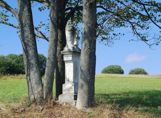 To dawna wieś królewska w Małopolsce. Jej znakiem rozpoznawczym są kamienne krzyże