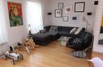 Szara sofa w salonie Kai Śródki