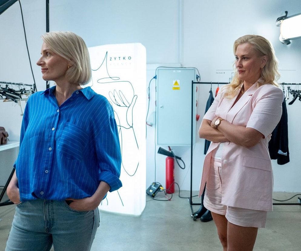 Dwie blondwłose kobiety, Justyna Zytko i Olga, rywalizują o Mirka w serialu Barwy szczęścia. Justyna, po prawej, ubrana w jasnoróżowy komplet, ma skrzyżowane ramiona. Olga, po lewej, w niebieskiej koszuli i dżinsach, patrzy w lewo. Tło sugeruje studio fotograficzne. Więcej o ich losach na portalu Super Seriale.