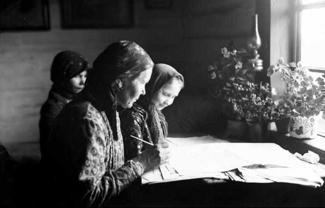 Wiejska kobieta z dziećmi pochylona nad arkuszem narodowego spisu powszechnego, 1921 