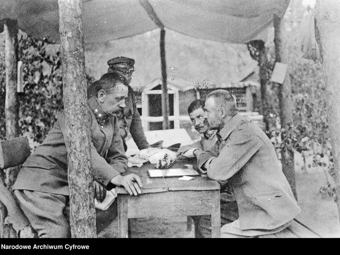 Legiony Polskie w miejscowości Wołczeck na Wołyniu. Józef Piłsudski gra w szachy z Jędrzejem Moraczewskim (1. z lewej) w Wołczecku. Obok widoczny oficer Legionów Polskich, rotmistrz Władysław Belina-Prażmowski (2. z lewej, za Piłsudskim)