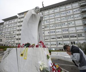 Świeczki, kartki z życzeniami, balony w kształcie serca, kwiaty składane są pod pomnikiem Jana Pawła II przed rzymską Polikliniką Gemelli