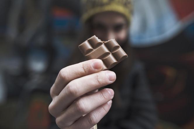 kawałek czekolady trzymany w rękach przez kobietę