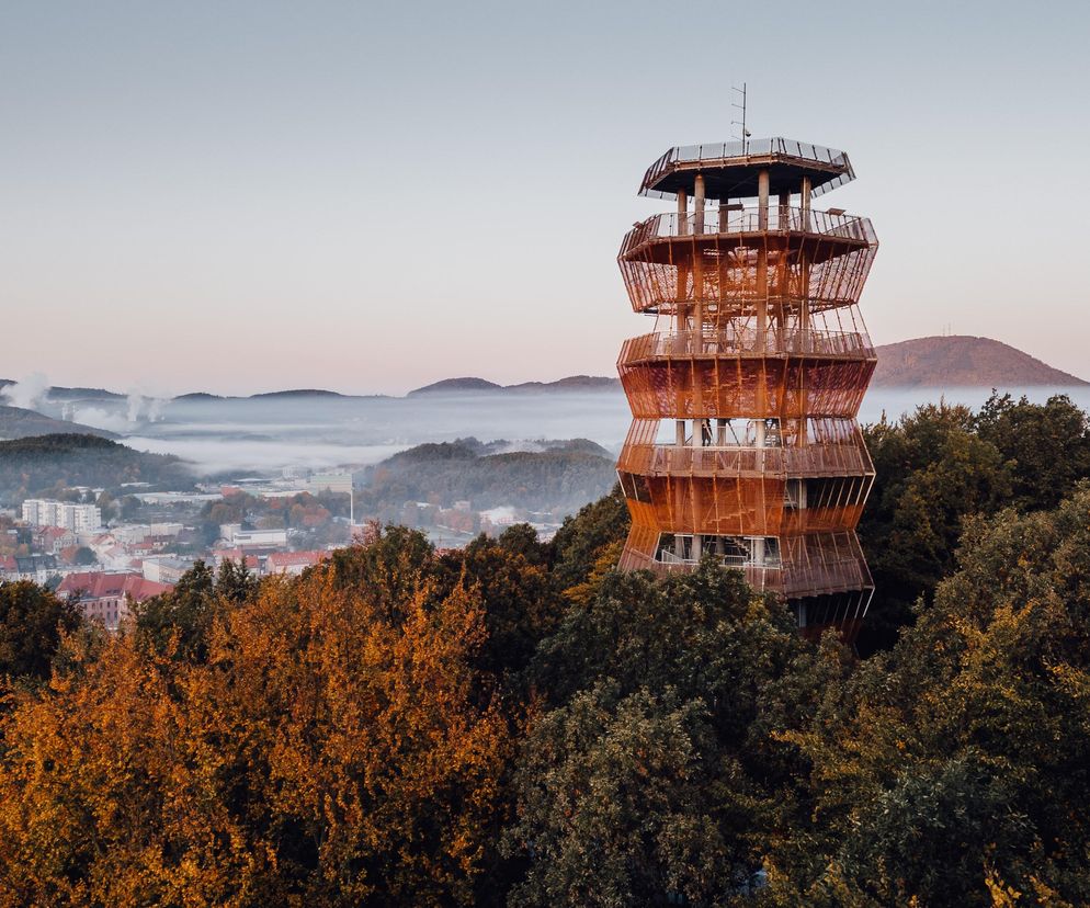 Wieża widokowa w Parku Miejskim im. Jana III Sobieskiego w Wałbrzychu, zrealizowana przez ISBA Grupa Projektowa. Konstrukcja z kortenowskiej stali w rudawym odcieniu, otoczona jesiennymi drzewami, góruje nad zamglonym miastem, oferując widoki na Sudety. O tym i innych projektach przeczytasz na Architektura Murator Plus.