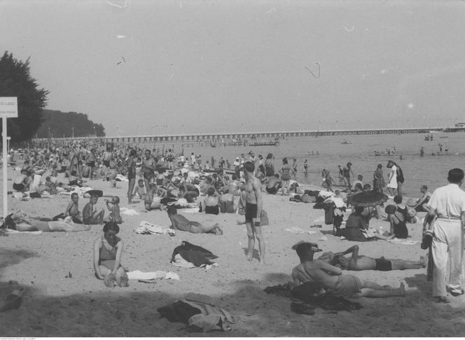 Plażowicze podczas wypoczynku. W tle molo. Zdjęcie z 1938 lub 1939 roku 