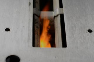 Płomień palący się pod powierzchnia rusztu w palenisku manualnym