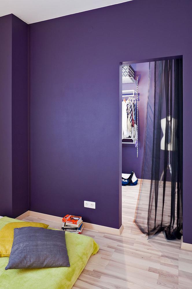 Granatowo-fioletowa ściana we wnętrzu pokoju