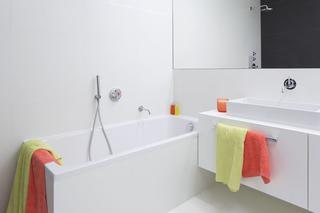 Minimalistyczna biała łazienka z wanną i prysznicem