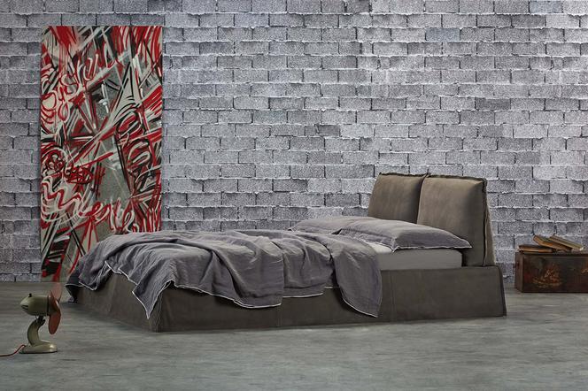 Szare łóżko tapicerowane w nowoczesnym kształcie