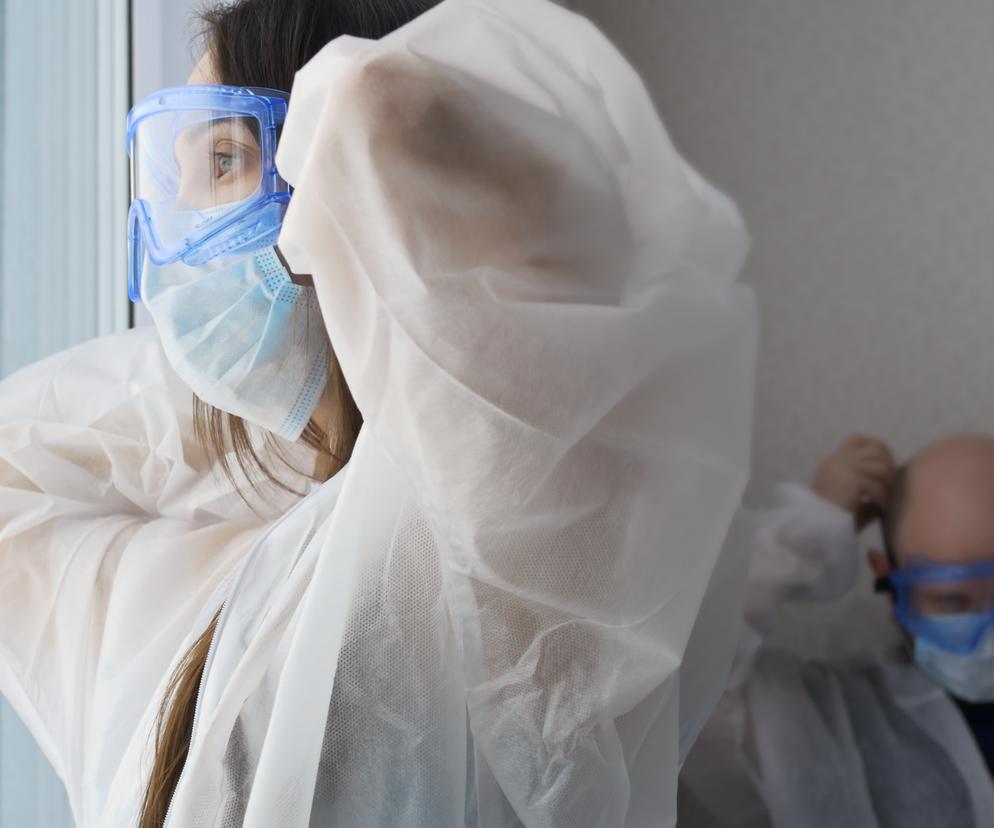 Lekarze w kombinezonach ochronnych