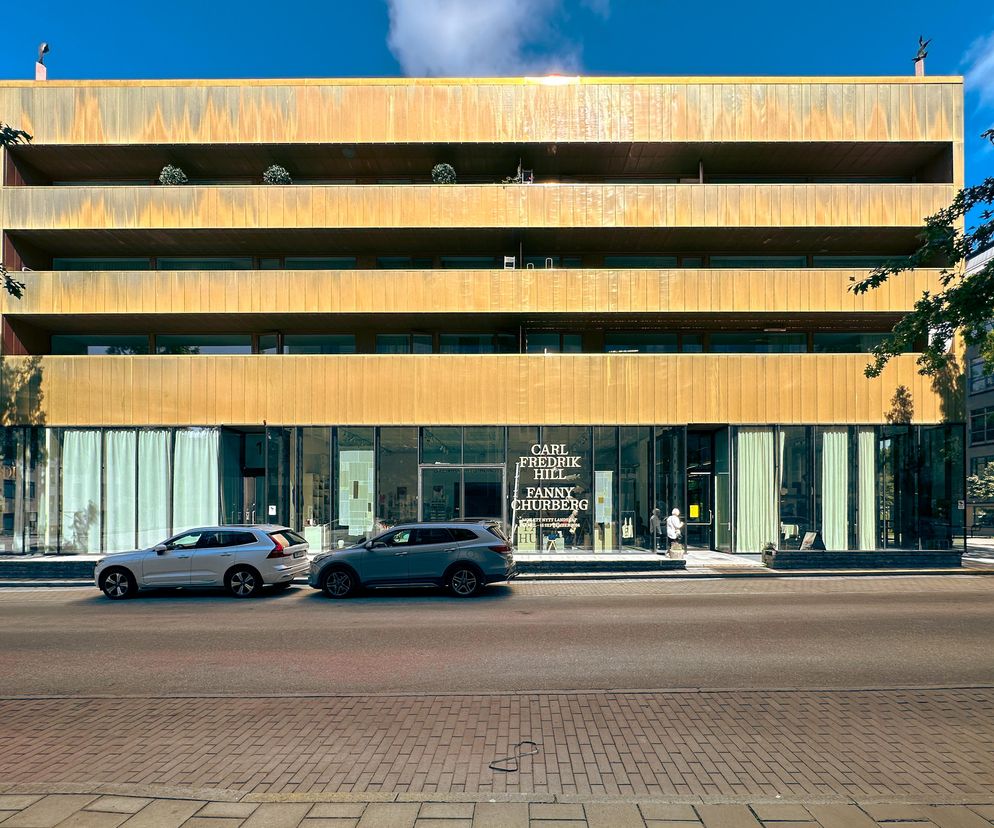 Sven-Harrys Konstmuseum w Sztokholmie, budynek o złotej, metalicznej fasadzie, z widocznymi przeszkleniami na parterze oraz balkonami na wyższych piętrach, symbolizujący połączenie sztuki i codziennego życia. O tym, jak powstawał ten ekscentryczny projekt, przeczytasz na Architektura Murator Plus.