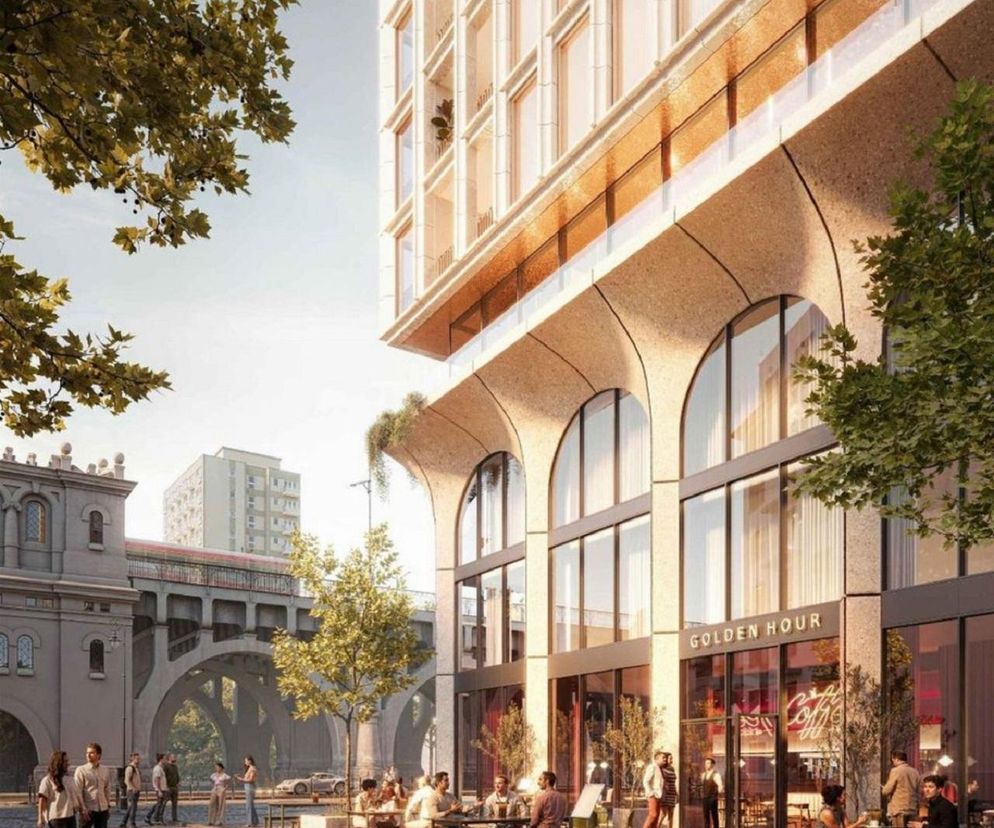 Wizualizacja planowanego apartamentowca na Powiślu w Warszawie, ukazująca charakterystyczne łuki parteru nawiązujące do mostu Poniatowskiego. Na dole widać kawiarnię „Golden Hour” z ogródkiem, a w tle most z przejeżdżającym tramwajem. O projekcie przeczytasz na Architektura Murator Plus.