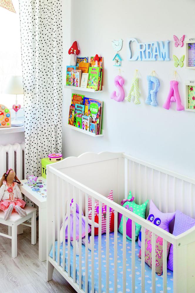 Biały pokój niemowlęcia z pastelowymi dodatkami