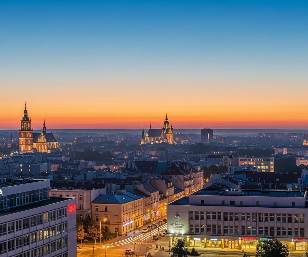 Panoramę miasta przedstawia widok z góry o zmierzchu. Horyzont dominuje gradient nieba, przechodzący od intensywnego błękitu na samej górze, przez pomarańcz i róż w centrum, aż po ciemniejszy odcień na styku z zabudowaniami. W oddali widoczne są liczne budynki, wśród których wyróżniają się sylwetki kilku kościołów ze spiczastymi wieżami, oświetlone żółtym światłem.

Na pierwszym planie znajdują się nowoczesne i starsze budynki mieszkalne oraz użytkowe. Na dachu jednego z nich widnieje duży, podświetlony napis CZZSTOCHÓRA. Uliczny ruch jest symbolizowany przez smugi świateł samochodowych, biegnące wzdłuż dróg, a wiele budynków ma włączone światła w oknach i wejściach, co tworzy ciepłe, żółte akcenty świetlne.