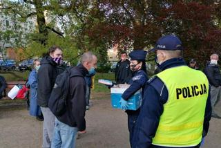 Policjanci rozdają maseczki bezdomnym