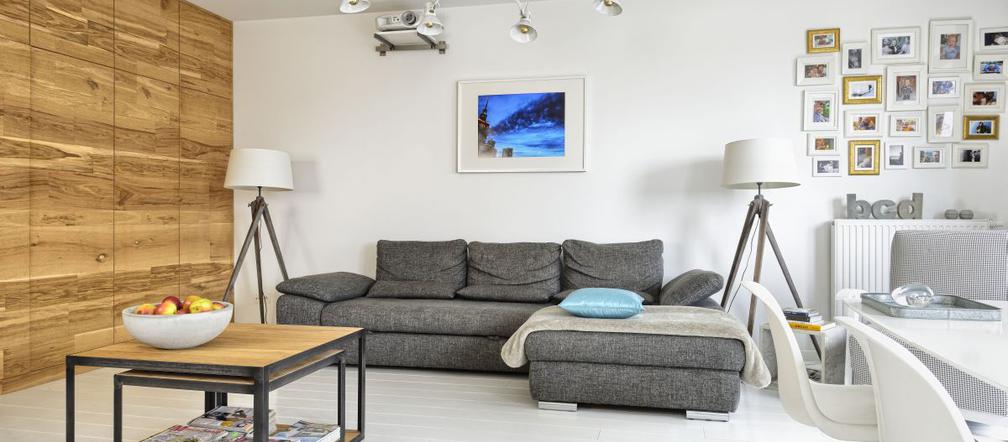 Szara, narożna sofa w białym salonie