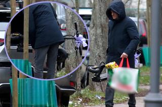 Zakapturzony Tusk wkłada hulajnogę z olbrzymią kokardką do wypasionej bryki. Wszystko nadzoruje żona