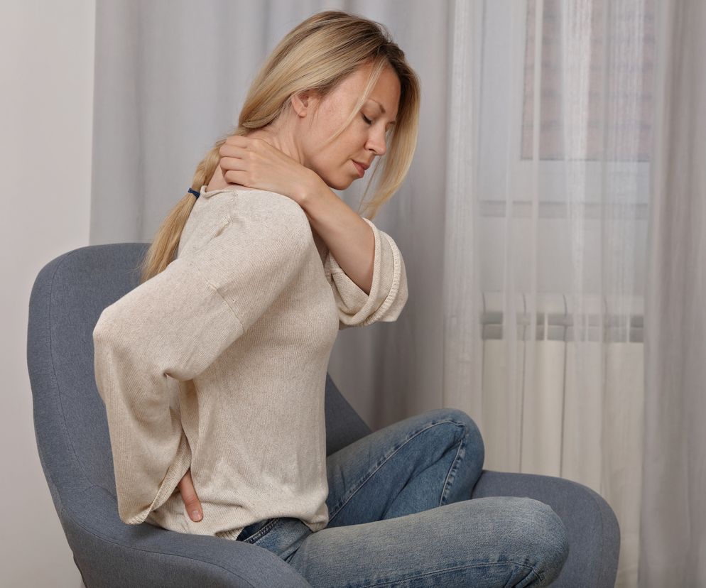 Kobieta trzymająca się za kark 