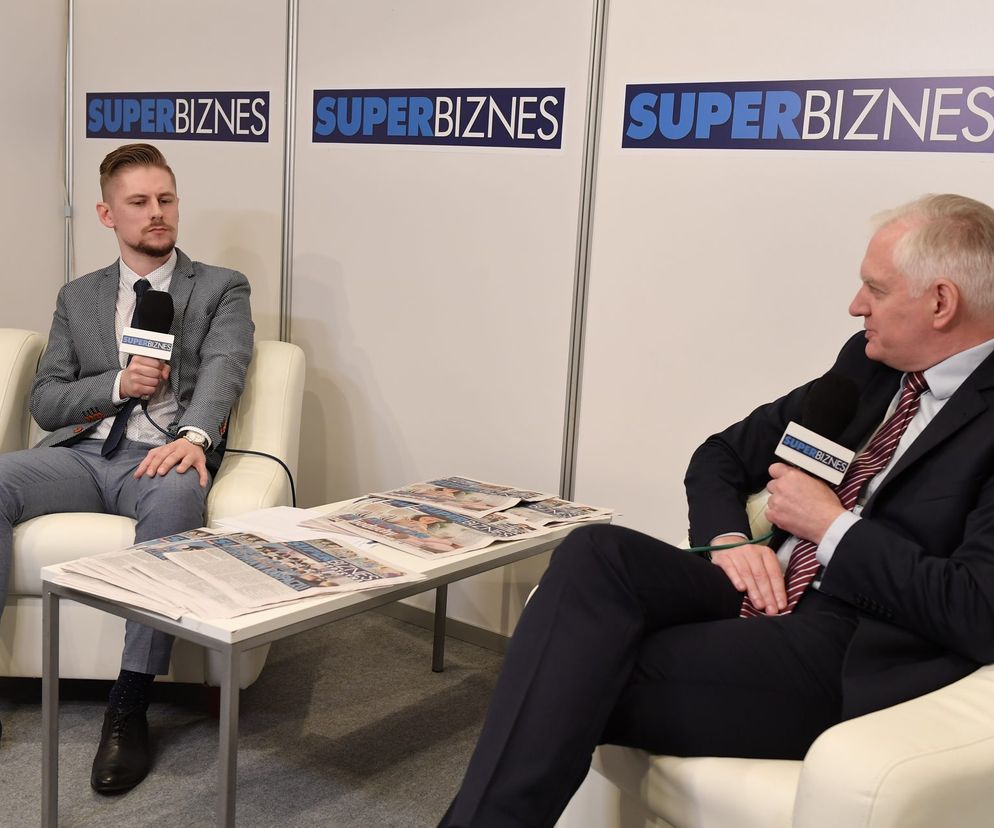 Dwóch mężczyzn, w tym Jarosław Gowin, w garniturach, siedzi naprzeciwko siebie w fotelach, trzymając mikrofony z logo Super Biznes, na tle ścianek z logotypem Super Biznes. Na stoliku leżą gazety. Zdjęcie z Europejskiego Kongresu Gospodarczego w Katowicach, relację można przeczytać na portalu Super Biznes.