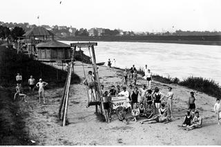 Plażowicze podczas wypoczynku. Widoczny sprzedawca lodów i huśtawka. Zdjęcie zrobione w 1926 roku 
