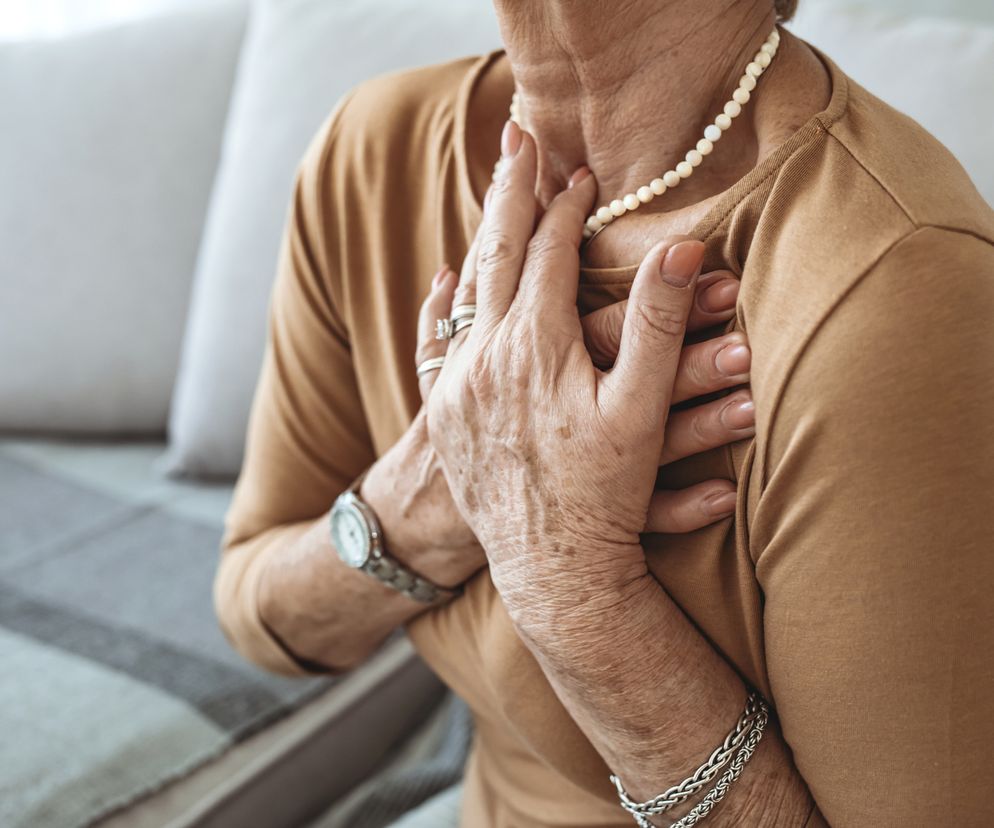 Stan przedzawałowy - starsza kobieta trzymająca sie za klatkę piersiową.