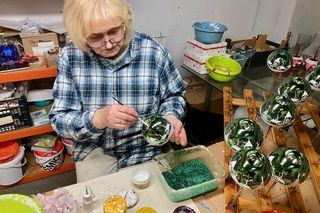 Pani Danuta dekoruje bombki w fabryce GabiGlass