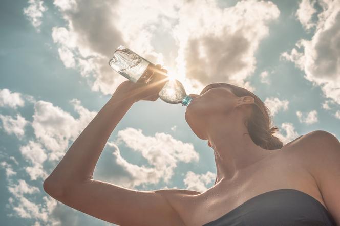 Kobieta pije wodę w słońcu