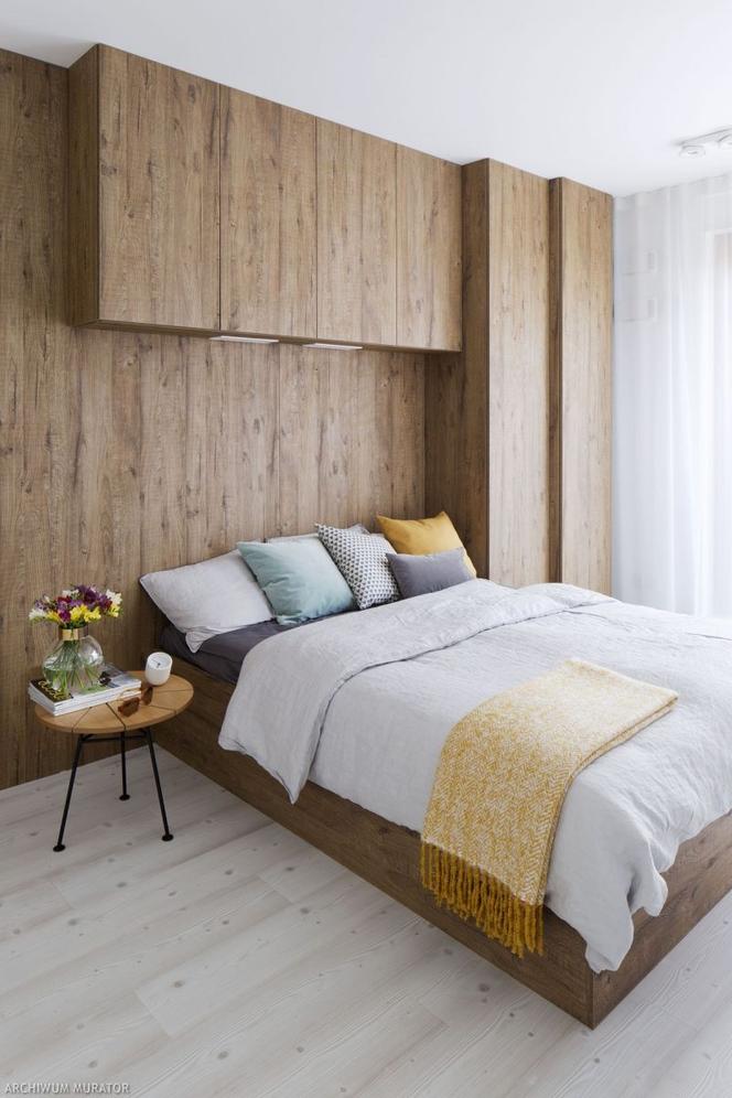 Drewniana ściana za łóżkiem w sypialni