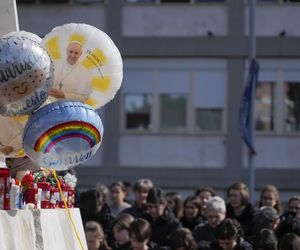 Świeczki, kartki z życzeniami, balony w kształcie serca, kwiaty składane są pod pomnikiem Jana Pawła II przed rzymską Polikliniką Gemelli